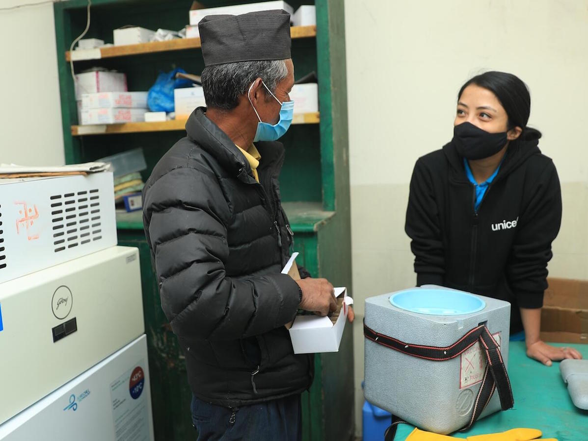 Mitthi Jirel (left), staff at the district hospital in Jiri in Dolakha District in northeastern Nepal, with UNICEF staff Preena Shrestha (right) in the hospital's vaccine storage room on February 26, 2021.