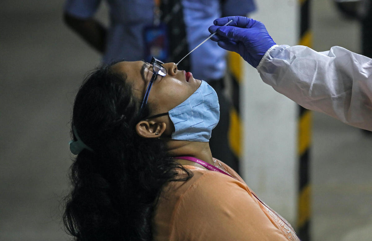 A health worker takes a nasal swab sample to test for COVID-19 at a facility in the Malad area of Mumbai, India, on April 30, 2021.