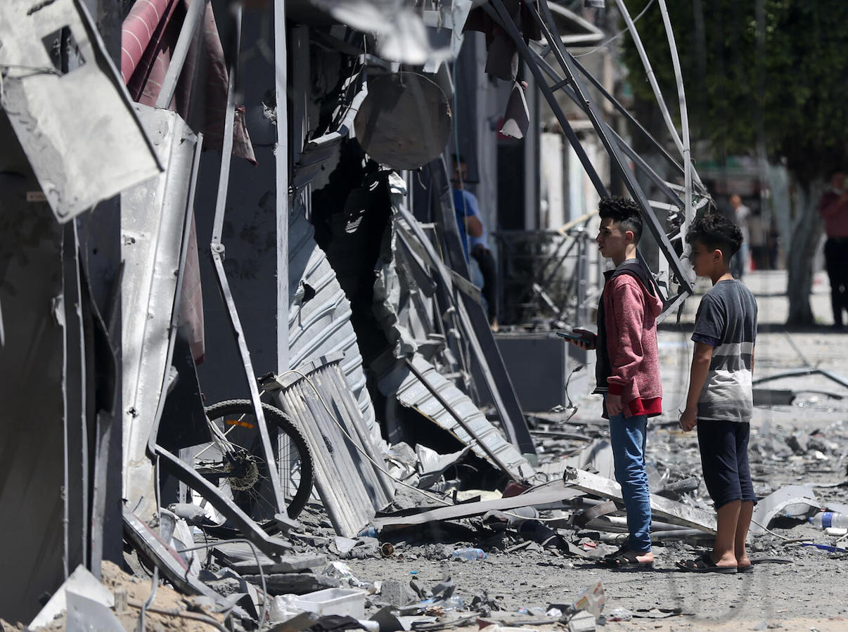 On May 17, 2021, Palestinian children walk in front of a house that was targeted by the Israeli bombardment in Gaza City.