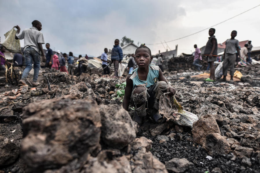Children stand amidst lava from the volcanic eruption of Mount Nyiragongo, which occurred late on May 22, 2021 in eastern Democratic Republic of the Congo.