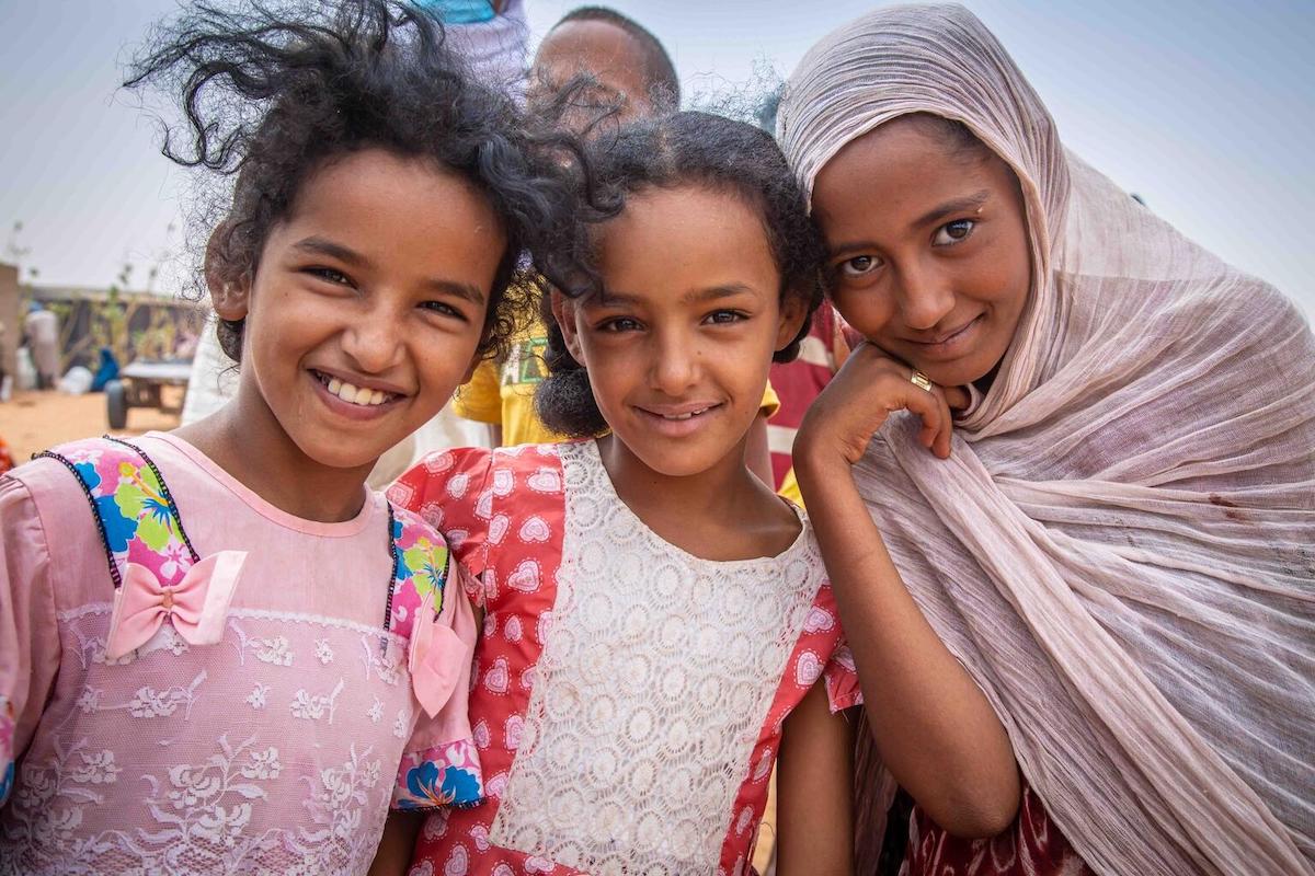 Three Malian girls pose outside the food distribution center at the UNICEF-supported Mbera refugee camp in Mauritania.