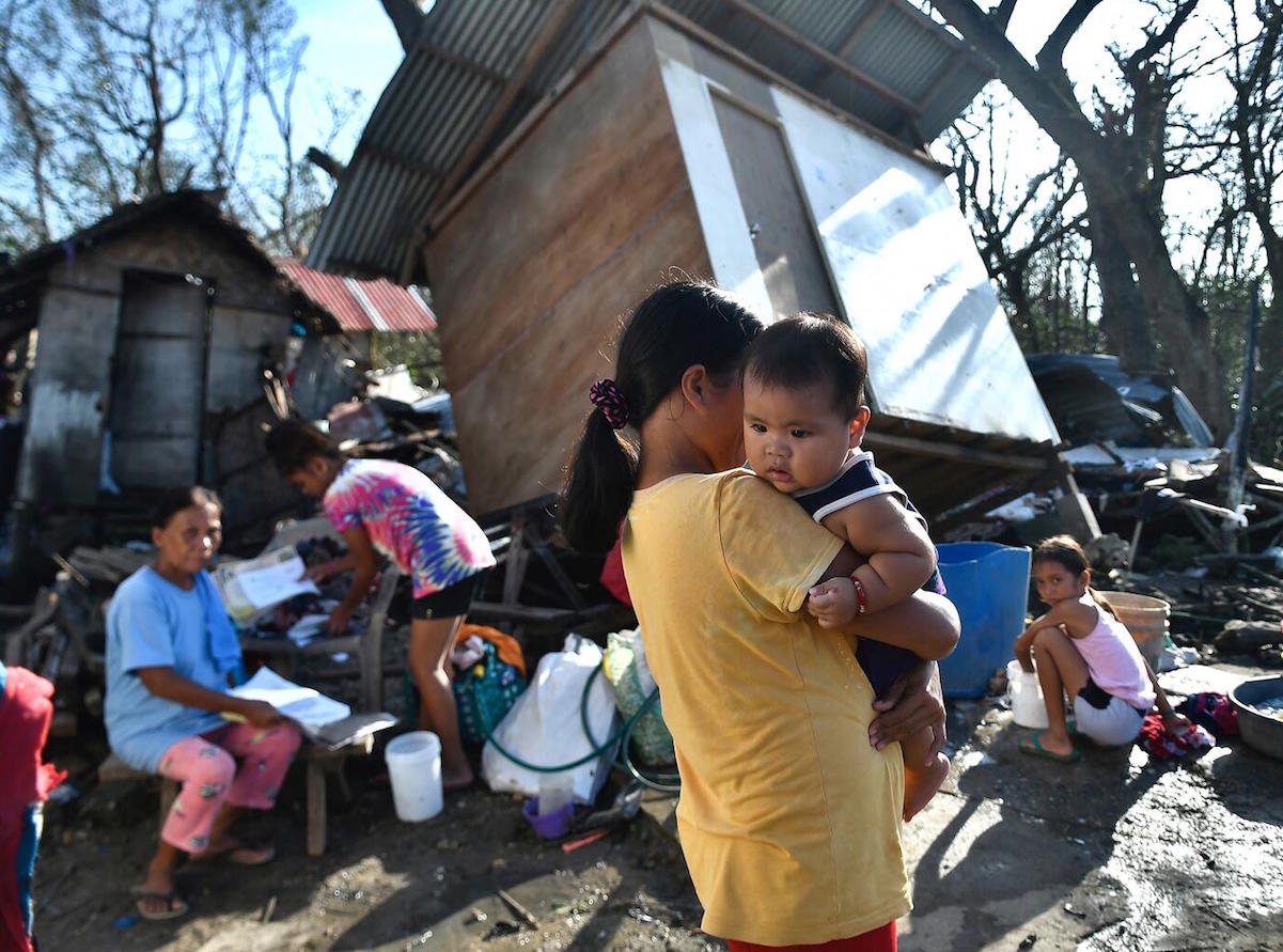 Residents gather next to their destroyed house in Carcar, Philippines' Cebu province on December 18, 2021, days after Super Typhoon Rai hit the city.