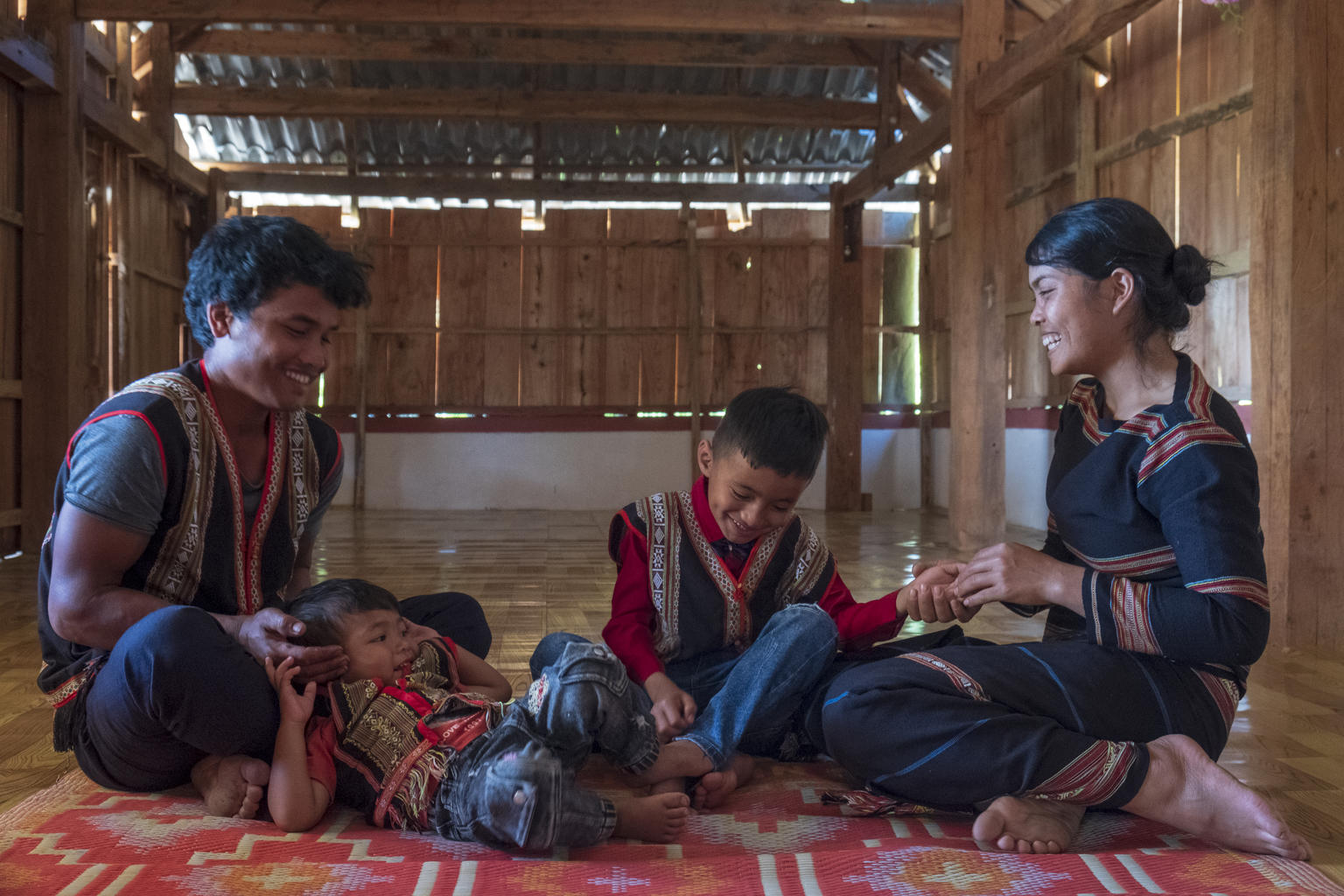 On 25 February 2020, Xu, 27, and his wife Del, 25, play with their two sons, Khon, 1, and Muih, 7, inside their home in Gia Lai, in the Central Highlands region of Viet Nam.