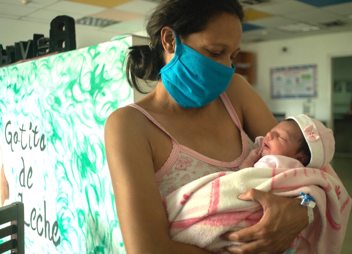 A new mother holds her baby, sleepy and full of breast milk, at a UNICEF-supported breastfeeding workshop at a health center in Caracas, Venezuela.