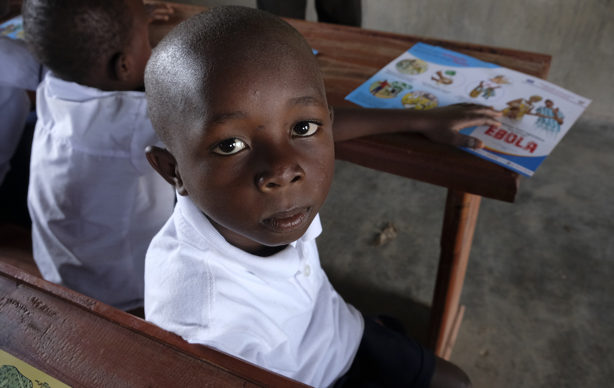 7-year-old Kambale of Beni, Democratic Republic of the Congo, sits in his UNICEF-supported classroom, where children are taught to wash hands to prevent the spread of infectious disease.
