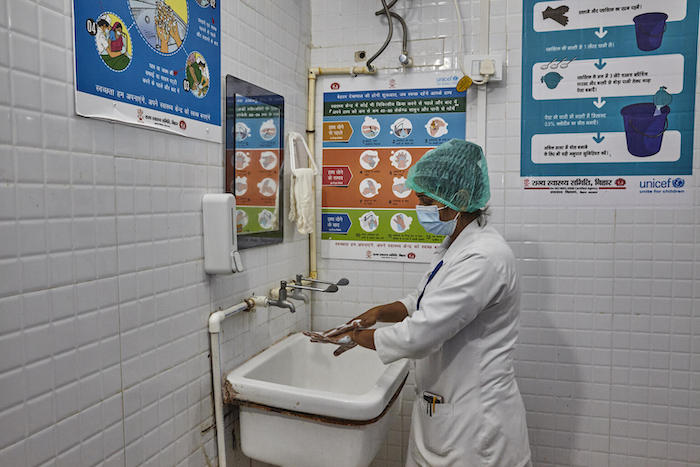 A nurse washes her hands before examining a patient at a hospital in Bhawanipur, Purnea, Bihar State, India.