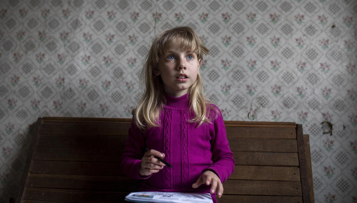 Vika, 8, from Avdiivka, eastern Ukraine, works on her homework in her relatives' house in Cherkasy oblast.