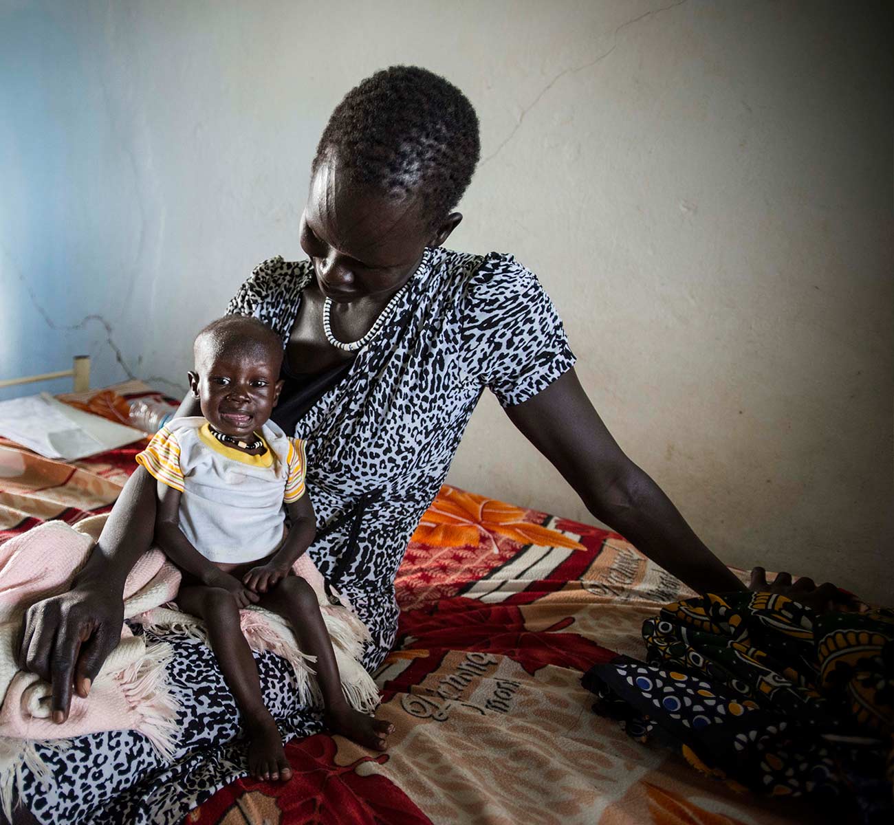 A South Sudanese mother holds her troubled child - Donation Form Background
