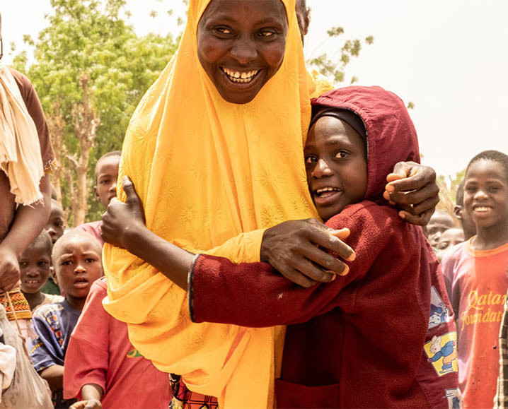 A mother and her child hugging and smiling.