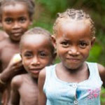 A group of children in rural Madagascar smile at the camera