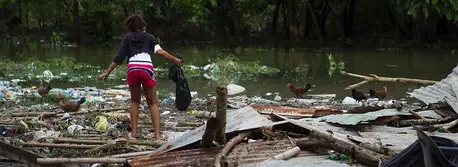 A Haitian girl searches through the remnants of her home for possessions after it was destroyed by Hurricane Matthew in 2016