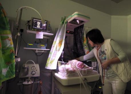Dr Iryna Kondratova tends to a newborn in a patient care room