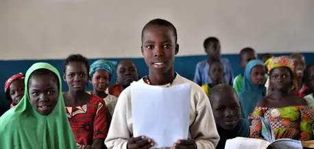 Gilbert, a 14-old Nigerian refugee living in Cameroon, holds a letter he wrote in reply to the question, "What does education mean to you?"