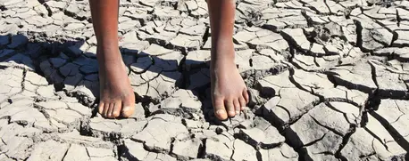 Child standing on a drying up dam