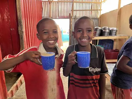Two boys enjoy a porridge breakfast at a UNICEF-supported primary school in Baidoa, southwestern Somalia.