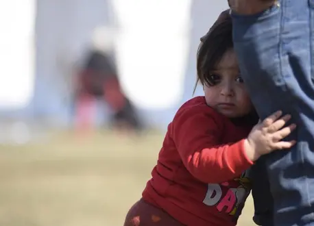 In Kahramanmaraş, Turkey, a little girl holds onto her father's leg five days after a pair of deadly earthquakes hit Turkey and Syria.