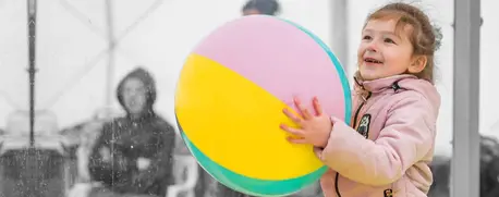 A child plays with a ball in a safe space at a UNICEF-UNHCR Blue Dot service center for Ukrainian refugees.