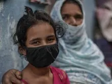 Mekak, 11, sits with her grandmother near a community toilet in the slums of Mumbai, India. UNICEF and partners are working to sustain urban slum sanitation and preparedness of schools during the COVID-19 public heatlh crisis. 