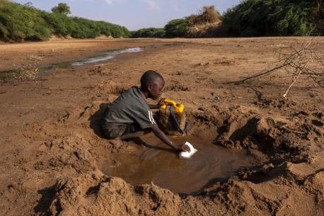 A young boy collects what little water he can from a dried up riverbed in Dollow Somalia, where severe drought has taken hold..