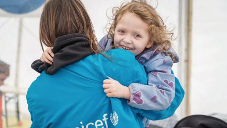 On 7 April 2022 at a Blue Dot hub in Isaccea border crossing, Romania, 5-year-old Emma plays with a UNICEF staff member. Emma, her mother Yulia, and her little brother arrived at the hub after traveling from Odessa, Ukraine.