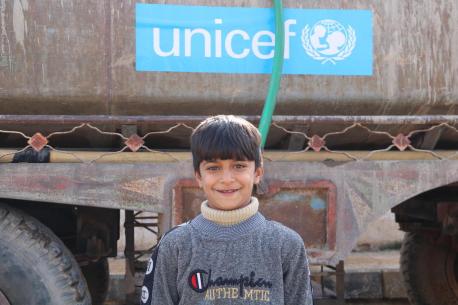Seif, 9, stands in front of a UNICEF water truck at Al Waha Al- Hussainia school in north rural Deir ez-Zor, Syria, on Dec. 20, 2022.