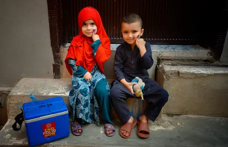 A brother and sister in Rawalpindi, Pakistan, show their fingers marked with ink indicating they have received the polio vaccine.