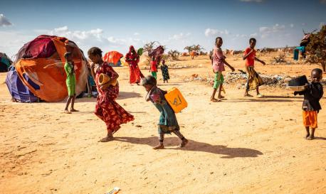 Children carry water at the Qurdubey camp in Dollow, Somalia, where UNICEF is providing humanitarian aid to families displaced by severe drought in the Horn of Africa, one of the world's worst climate change-related disasters.