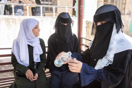 Jamila, far right, a 17-year-old student, pours water from a bottle while hanging out with her friends at the yard of Al-Zahra'a School in Dhamar Governorate, Yemen.