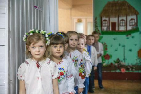 On Feb. 11, 2023, children line up in their kindergarten classroom in Dymer, Kyiv region, Ukraine, where UNICEF helped rehabilitate the school’s emergency shelter.  In order for children to continue attending schools and kindergartens, to socialize and be safe, UNICEF and partners are helping schools and kindergartens in the affected areas rehabilitate and equip their shelters.