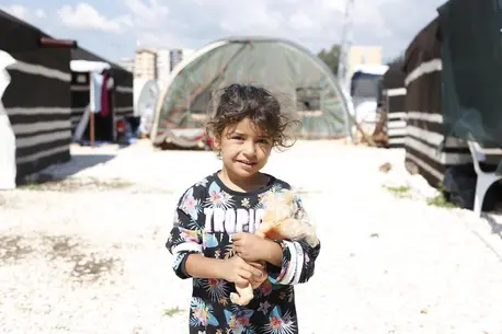 A little girl holds her toy at a temporary shelter in Hatay, Türkiye on May 1, 2023, after two devastating earthquakes hit southeast Türkiye.