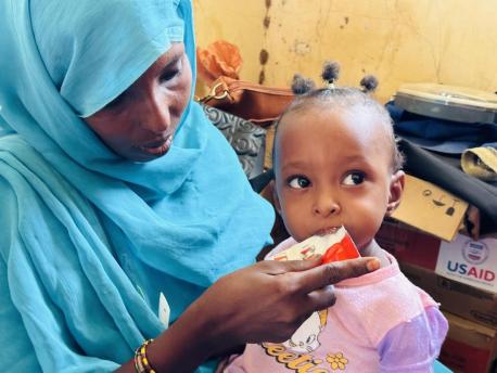 A child with severe acute malnutrition eats Ready-to-Use Therapeutic Food after a nutrition screening organized by UNICEF and partners in Sudan's Kassala state on May 24, 2023.
