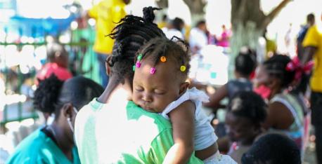 A girl sleeps on her mother’s shoulder at a mobile clinic organized by UNICEF and the Ministry of Health for families displaced due to violence in Cité Soleil, a neighborhood of Port-au-Prince, Haiti.