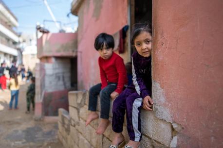Two children sit on a wall in Lebanon, where an economic crisis and related shocks have left families increasingly vulnerable.