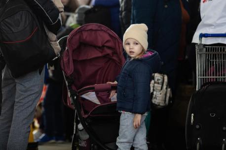 A child refugee from Ukraine stands in line with her mother at the border crossing between Ukraine and Moldova at Palanca on March 24, 2022. 