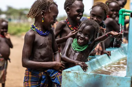 A group of children wash their hands and faces using a water point UNICEF helped install outside a health center in Omorate, SNNP Region, Ethiopia.