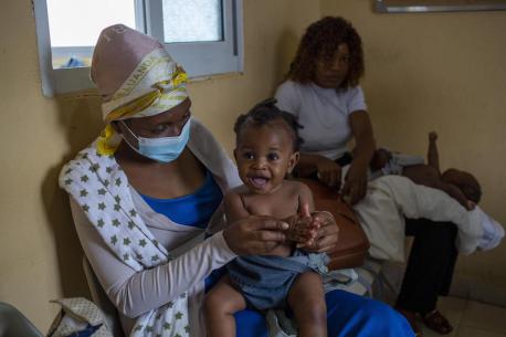 Nine-month-old Lwisani is held by her mother prior to receiving a dose of measles and rubella vaccine at Catambor Health Centre in Luanda, Angola
