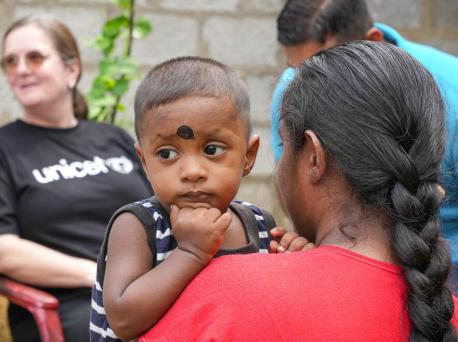 A mother holds her son as UNICEF and country officials meet to discuss needs of vulnerable families in Sri Lanka.