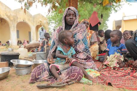 On June 17, 2023, Mariam Djimé Adam, 33, sits in the yard of a secondary school in Chad. She arrived from Sudan the previous day with her eight children.
