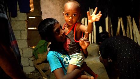Ariesh, 10, holds his brother Aswin, almost 2, inside their home in rural Sri Lanka.