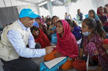 A UNICEF staff member visits with students inside a UNICEF-supported temporary learning center in flood-affected Jatt Shehzad village, Dadu district, Sindh province, Pakistan.