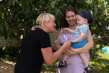 A UNICEF-supported visiting nurse greets Valeriia and her son Vladik in Pavlohrad, Ukraine on July 3, 2023.
