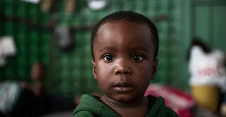 A migrant boy stands in the women's section of the Al-Nasr detention center in Zawiya, Libya.