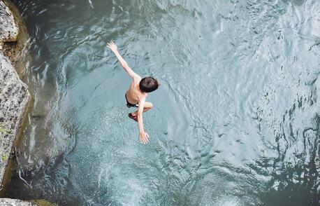 View from above of boy jumping in water