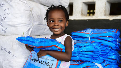 Marie, a 2 years old girl, is happy to receive a mosquito net, in Grand-Bassam, in the South of Côte d’Ivoire.