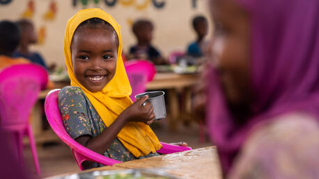 A girl enjoys lunch with friends at Kabasa Primary School in Dollow, Somalia, during a visit by UNICEF.