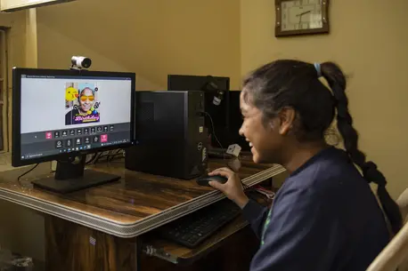 Young smiling girl looking at computer screen