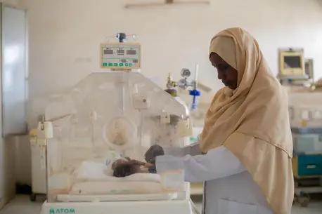 Sudan Auatf Mater Jaber, a pediatric nurse at UNICEF-supported Wad Madani Children's Hospital in Wad Madani, Gezira State, Sudan, tends to a sick baby in the neonatal unit.