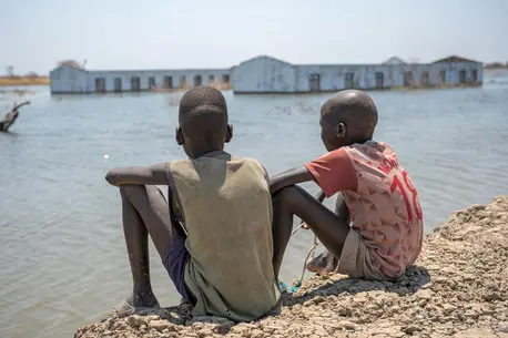 Two boys look out at their flooded school in Bentiu, Unity State, South Sudan, an area that suffered extensive flooding, an impact of climate change.