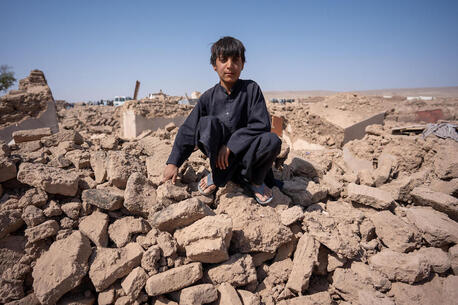Eleven-year-old Milat sits in the rubble of his home in Injil district, Afghanistan on Oct. 11, 2023 after one of several earthquakes that hit Herat Province that month.