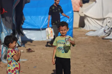 Yame , 5, holds bottled water delivered by UNICEF in a camp for displaced people in Khan Younis, southern Gaza, on Nov. 15, 2023.
